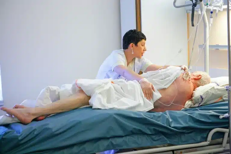 Enfermeira realiza manobra em paciente acamado para evitar escaras em idosos